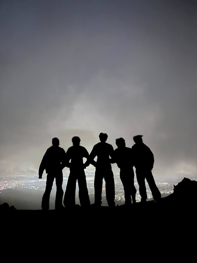the folk team posing dramatically on a hill at night